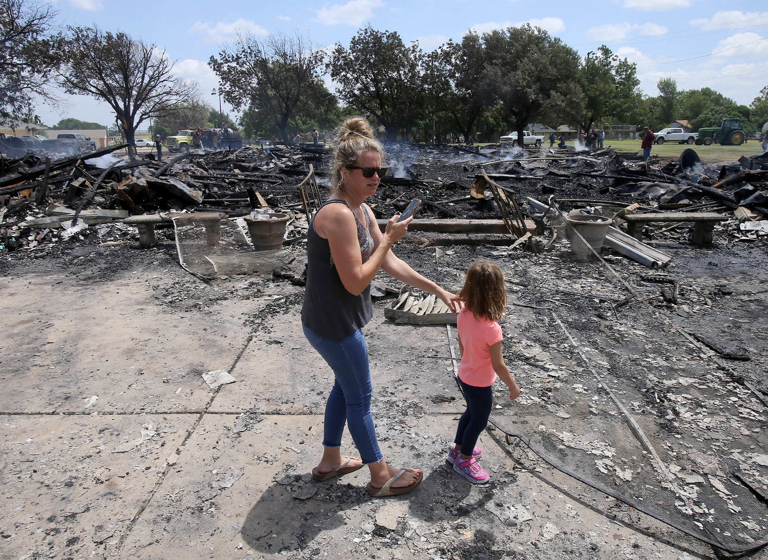 Catherine Halfmann and her 4-year-old daughter, Emma, stand near debris July 29, 2019, after fire destroyed the Church of the Visitation in Westphalia, Texas. Since 1883 the parish has served the Catholic community of southwestern Falls County, many of whom are descendents of immigrants from the northwest German region of Westphalia.